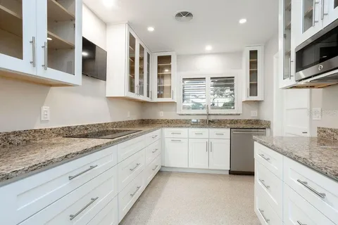 a kitchen with stainless steel appliances granite countertop a stove and a sink
