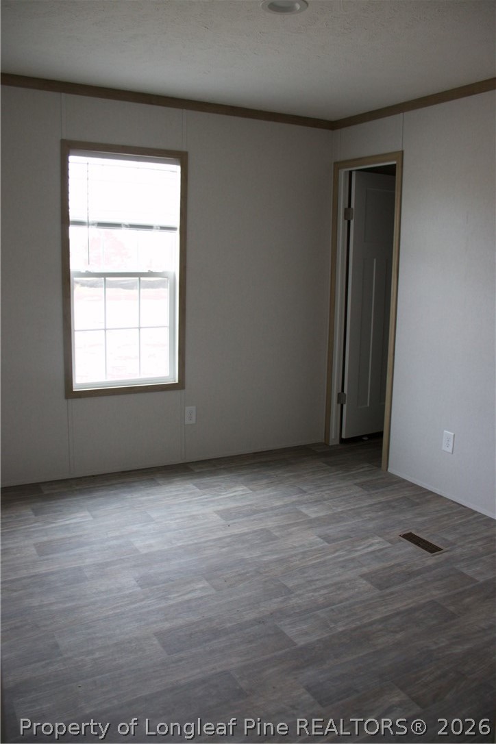 2701 Emma Jane Road St. Pauls, NC 28384 - Photo 6 of 9 an empty room with wooden floor and windows