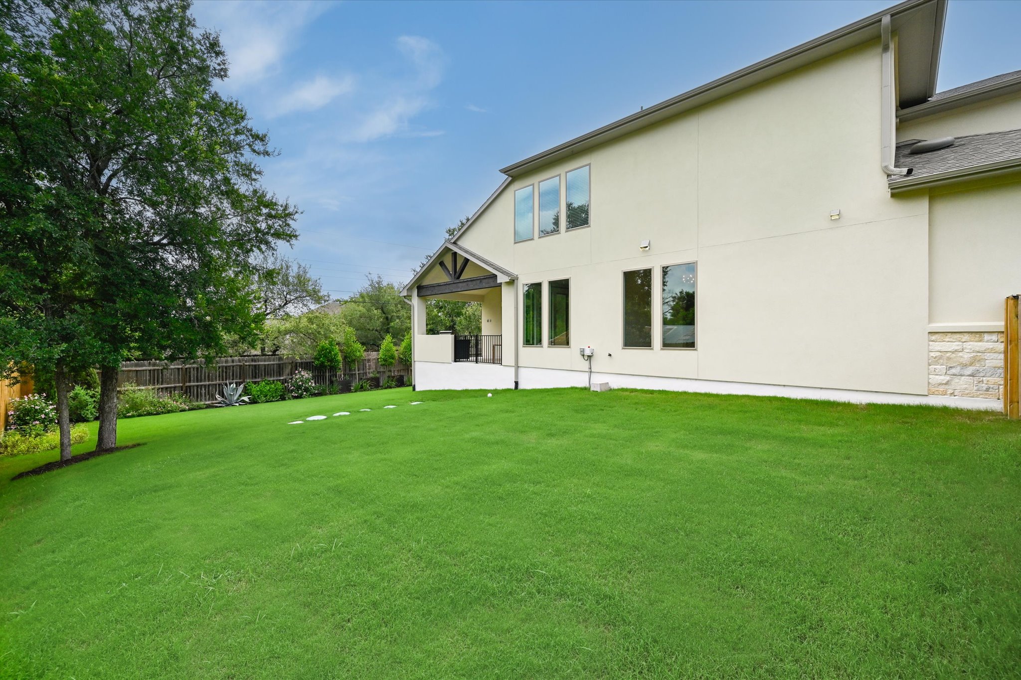 913 Presa Arriba Road Austin, TX 78733 - Photo 28 of 30 A spacious backyard with mature trees provides ample green space for outdoor activities and relaxation.