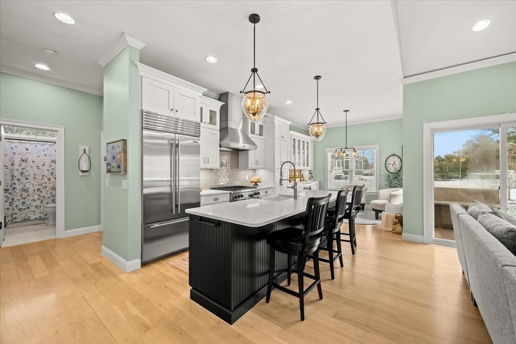 34 Palmer River Road Swansea, MA 02777 - Photo 12 of 42 a kitchen with stainless steel appliances kitchen island granite countertop a table chairs and a chandelier
