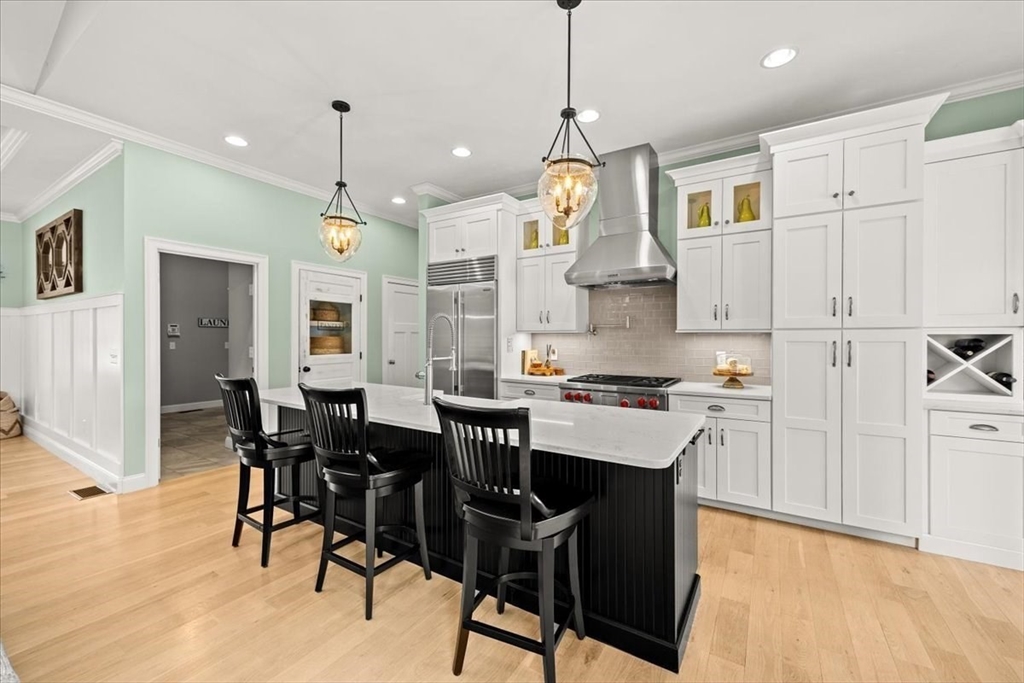 34 Palmer River Road Swansea, MA 02777 - Photo 13 of 42 a kitchen with stainless steel appliances kitchen island granite countertop a table chairs and a refrigerator