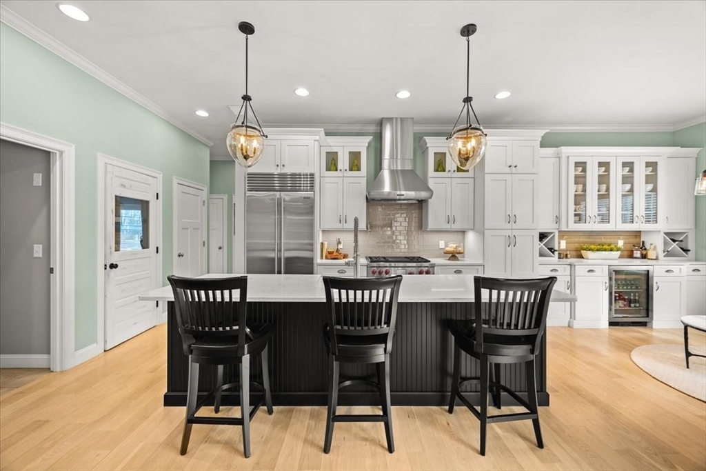 34 Palmer River Road Swansea, MA 02777 - Photo 16 of 42 a kitchen with stainless steel appliances kitchen island granite countertop a dining table chairs and white cabinets