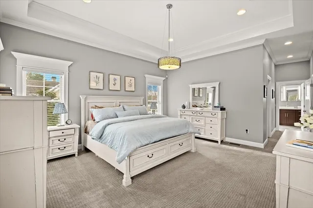 a spacious bedroom with a bed and a chandelier
