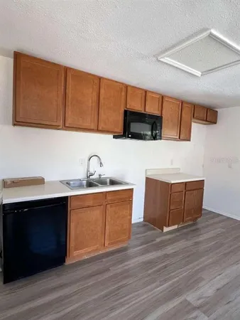 a kitchen with stainless steel appliances granite countertop a sink a stove and a wooden floors