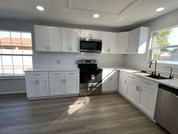 a kitchen with granite countertop white cabinets and white appliances