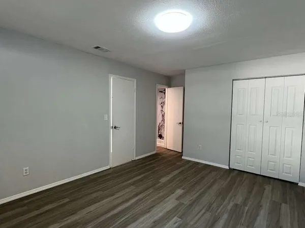 a view of an empty room with wooden floor
