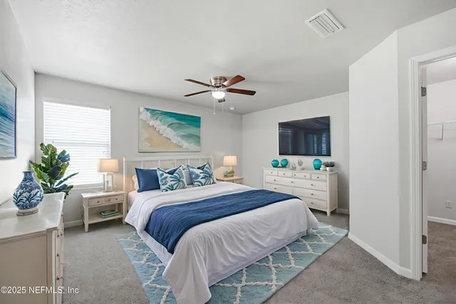 a bedroom with a bed a chandelier and a flat screen tv