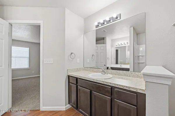 a bathroom with a granite countertop sink and a mirror