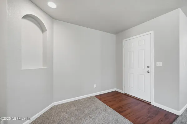 a view of room with hardwood floor and hallway