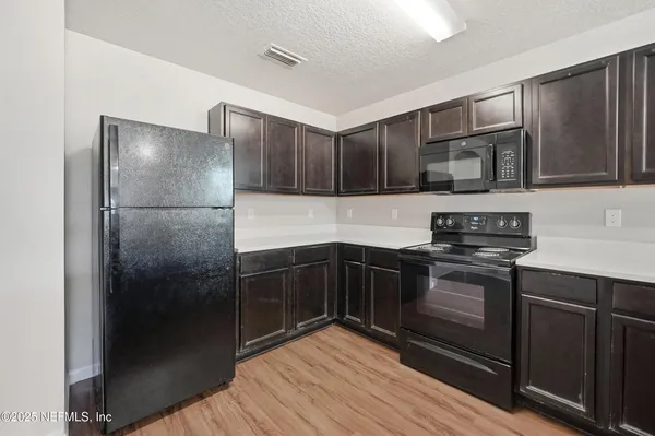 a kitchen with stainless steel appliances granite countertop a refrigerator and a stove top oven