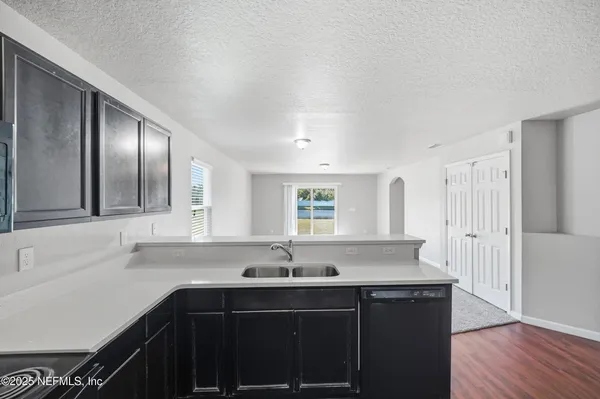 a kitchen with granite countertop a sink and cabinets