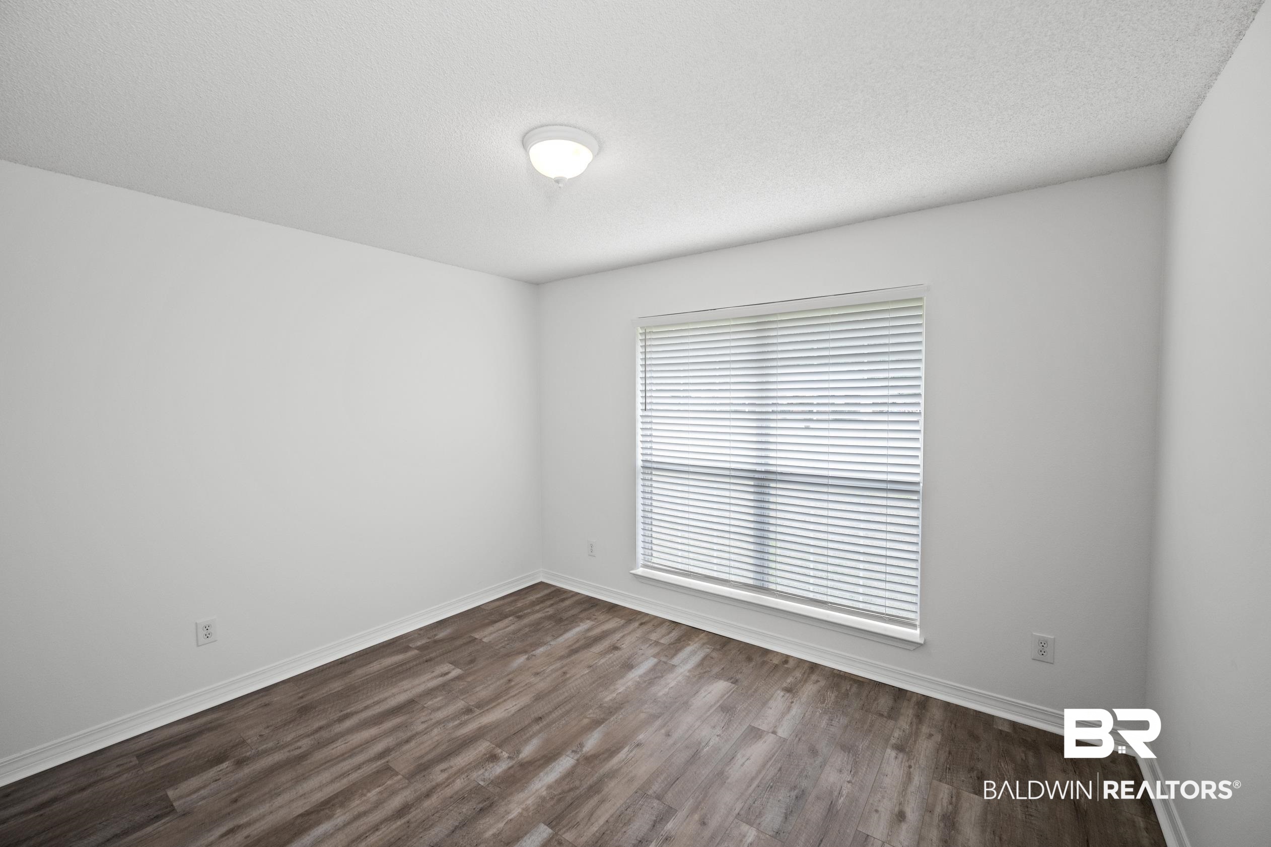 306 Monteith Oaks Drive Foley, AL 36535 - Photo 18 of 38 Spare room featuring dark wood-style flooring and a textured ceiling