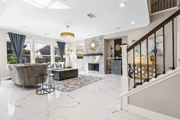 a living room with furniture a fireplace and a dining table with wooden floor