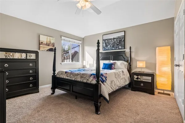 a bed sitting in a bedroom next to a window with a baby crib