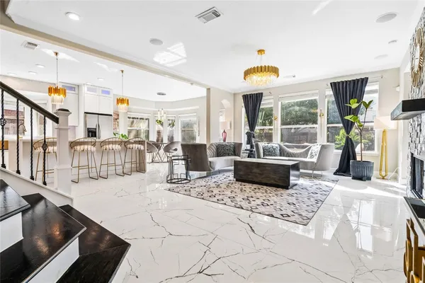 a living room with patio furniture and a chandelier