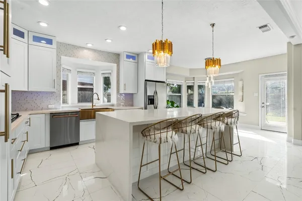 a kitchen with stainless steel appliances kitchen island granite countertop a table and chairs in it