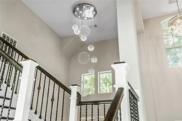 a view of a hallway with wooden floor and a chandelier