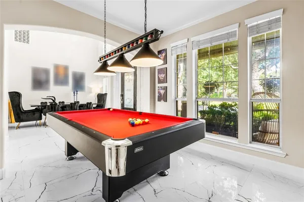 a room with pool table and windows