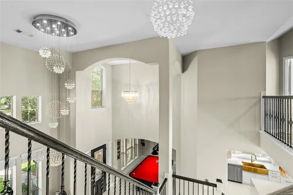 a view of a hallway with windows and chandelier