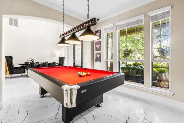 a room with pool table and windows