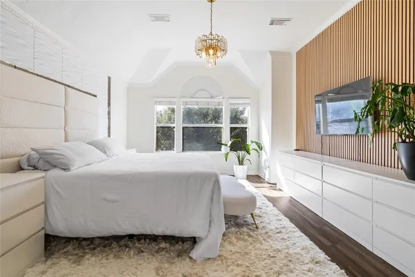 a bedroom with a bed a mirror and a window