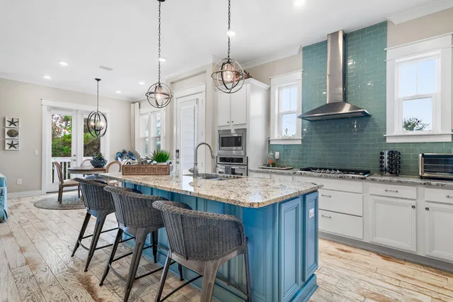 a kitchen with stainless steel appliances kitchen island granite countertop a stove top oven a sink a counter space and cabinets