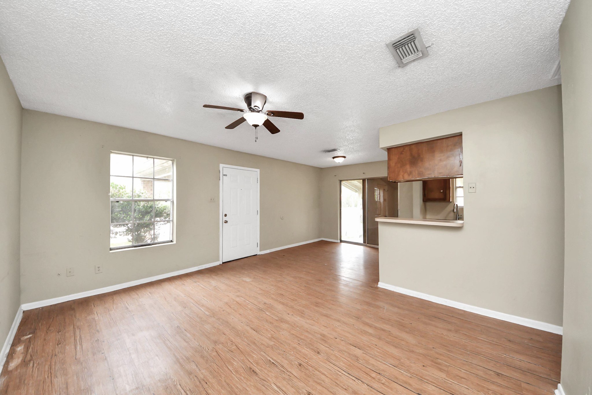 1006 Perry Street, Unit 100 Cleveland, TX 77327 - Photo 11 of 38 a view of an empty room with a window and wooden floor