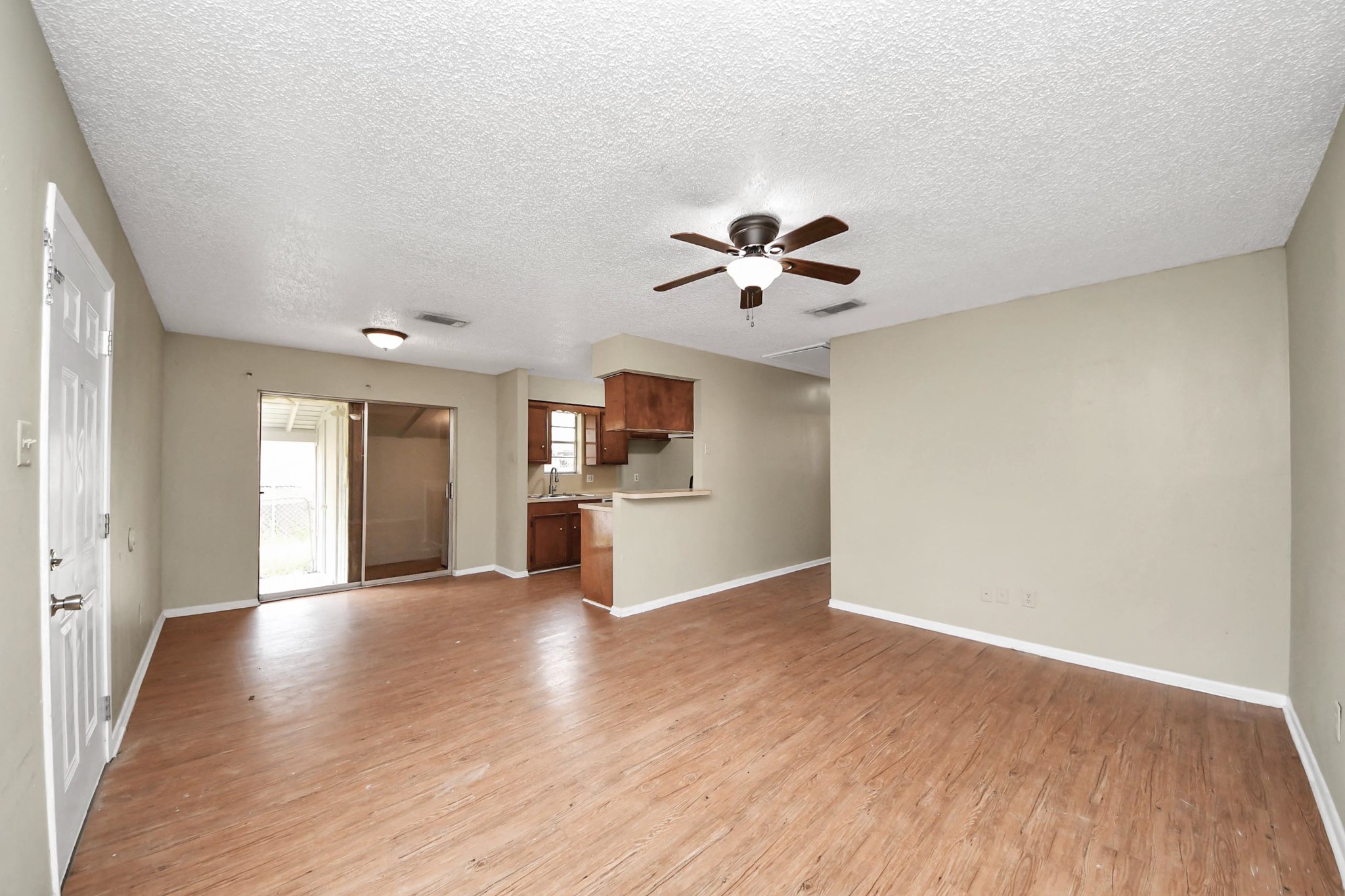 1006 Perry Street, Unit 100 Cleveland, TX 77327 - Photo 12 of 38 a view of an empty room with a kitchen and wooden floor