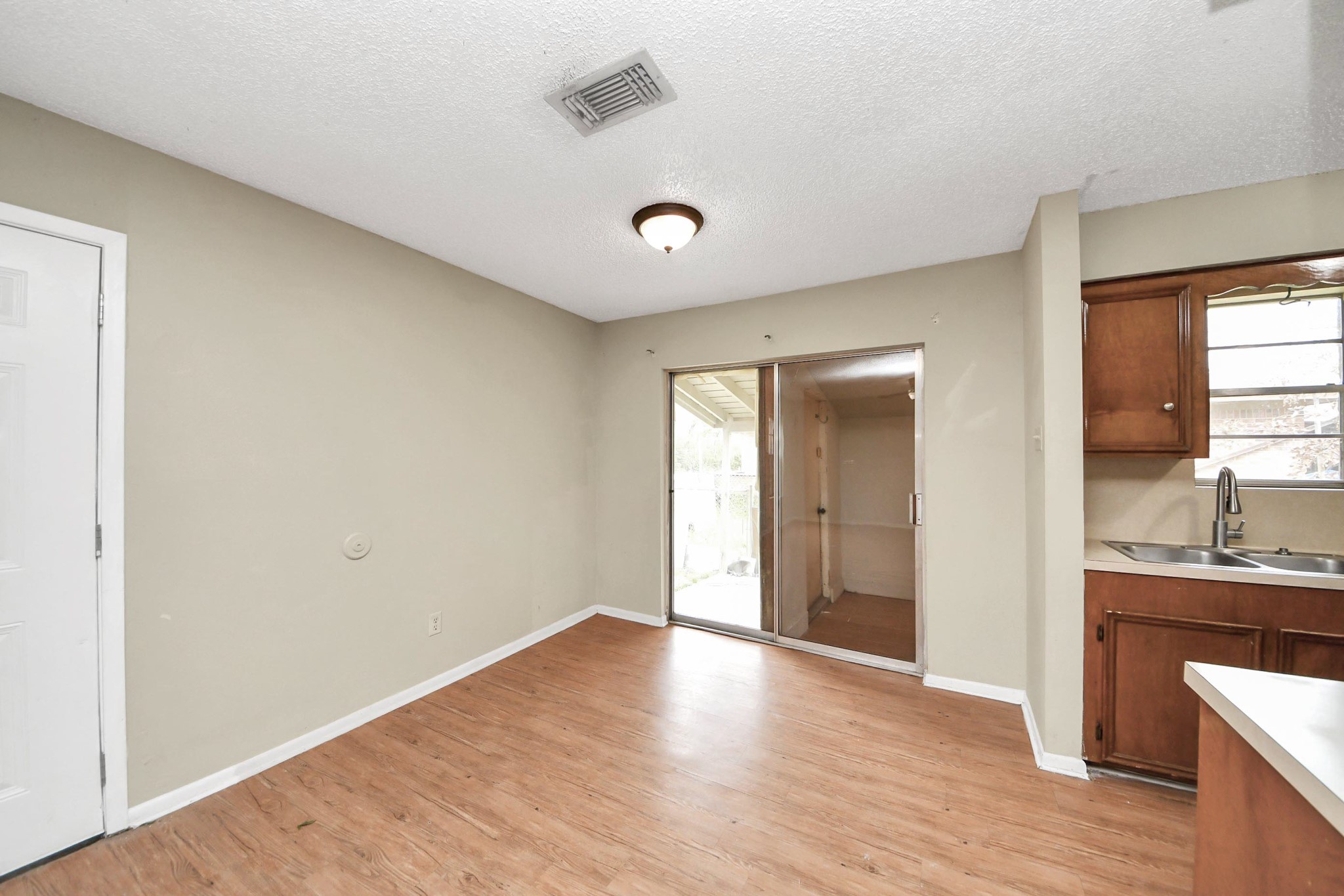 1006 Perry Street, Unit 100 Cleveland, TX 77327 - Photo 14 of 38 a view of a kitchen cabinets a sink and wooden floor