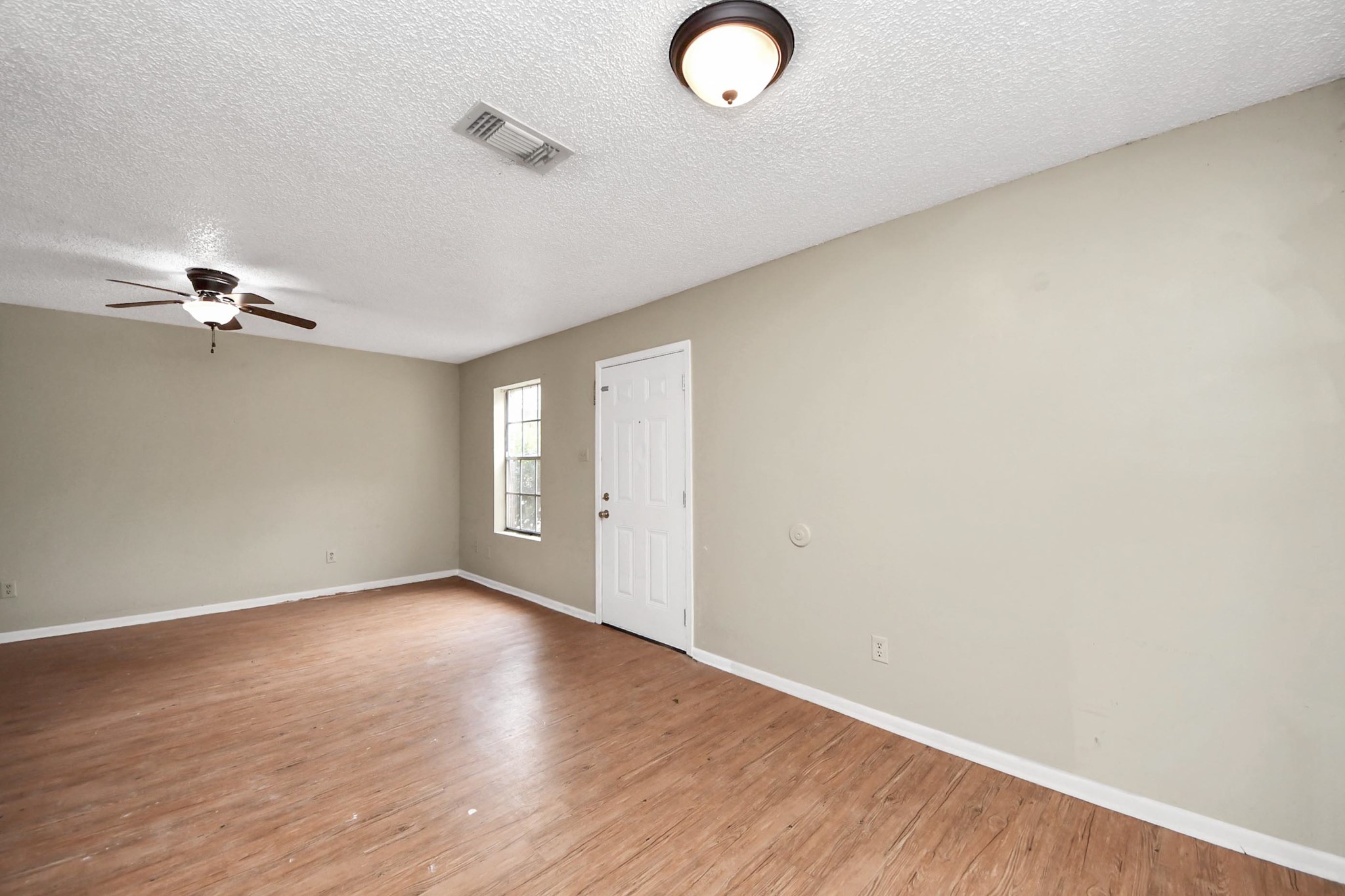 1006 Perry Street, Unit 100 Cleveland, TX 77327 - Photo 17 of 38 a view of an empty room with wooden floor and a window
