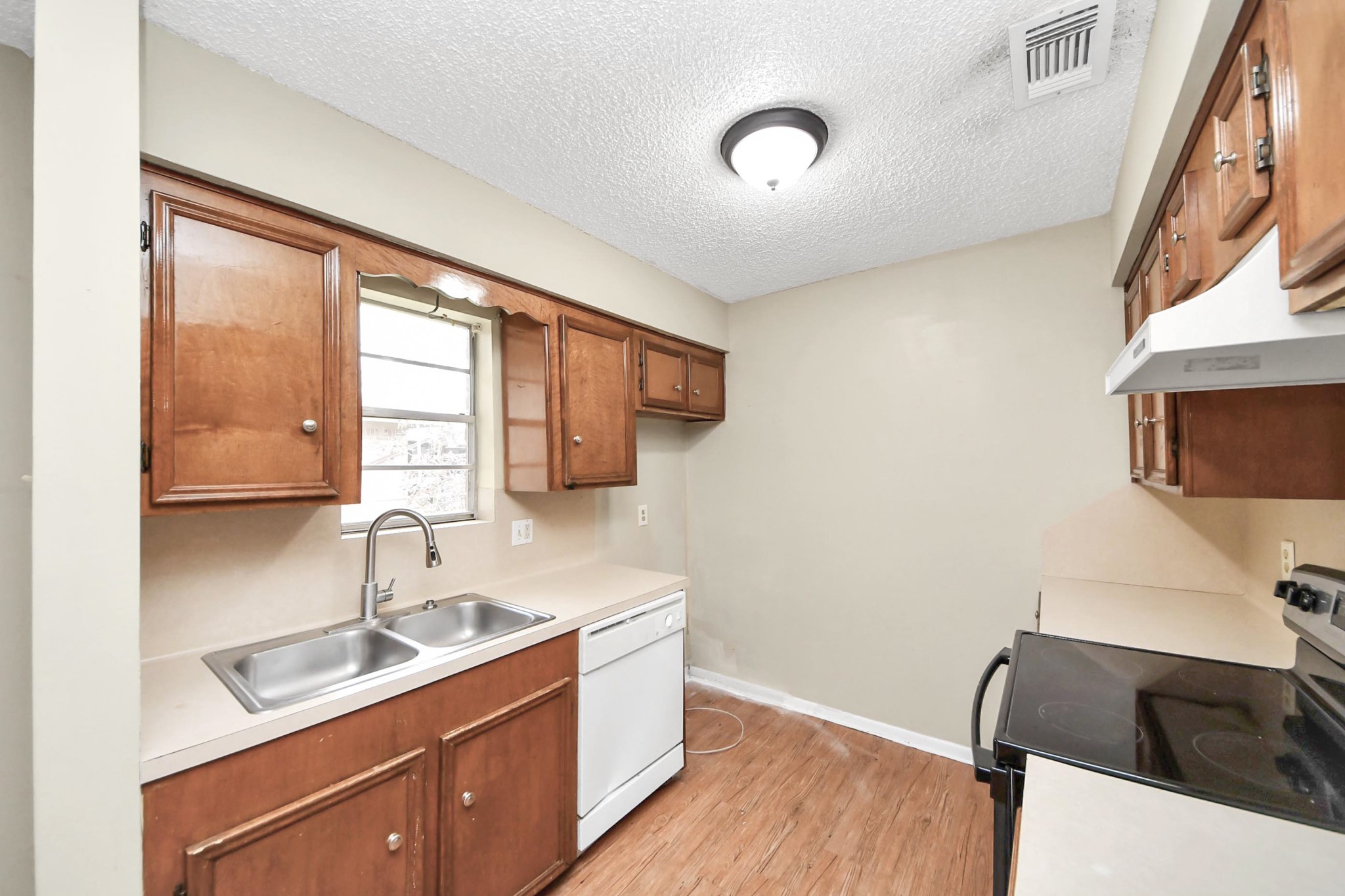 1006 Perry Street, Unit 100 Cleveland, TX 77327 - Photo 19 of 38 a kitchen with a sink and a stove top oven