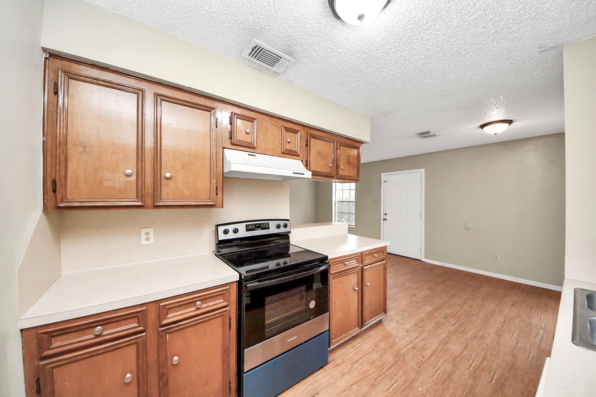 1006 Perry Street, Unit 100 Cleveland, TX 77327 - Photo 22 of 38 a kitchen with granite countertop stainless steel appliances a stove top oven and sink