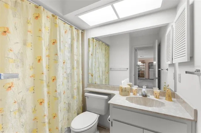 a bathroom with a sink a toilet and shower curtain