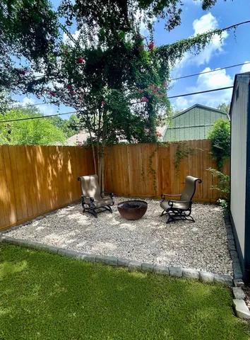 a view of a fire pit with large trees