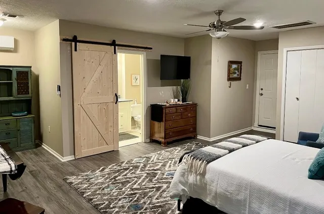 a bedroom with a bed dresser and a flat tv screen