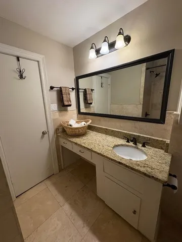 a bathroom with a granite countertop sink a mirror and vanity
