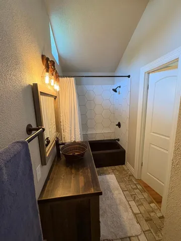 a bathroom with a sink a mirror and a shower