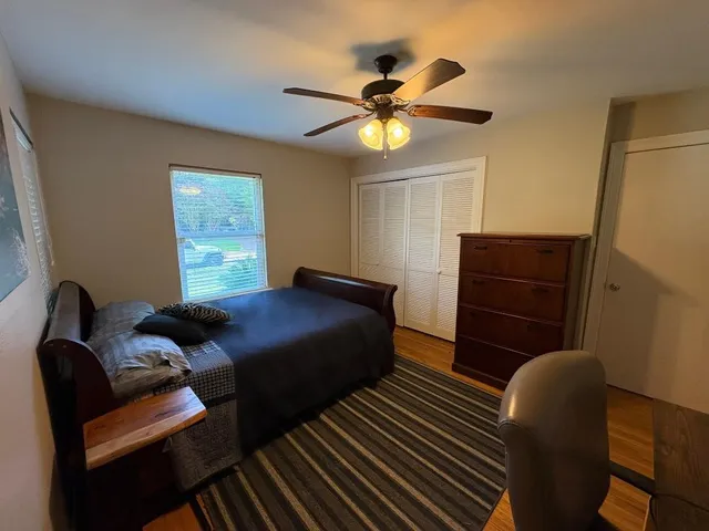 a bedroom with a bed and wooden floor