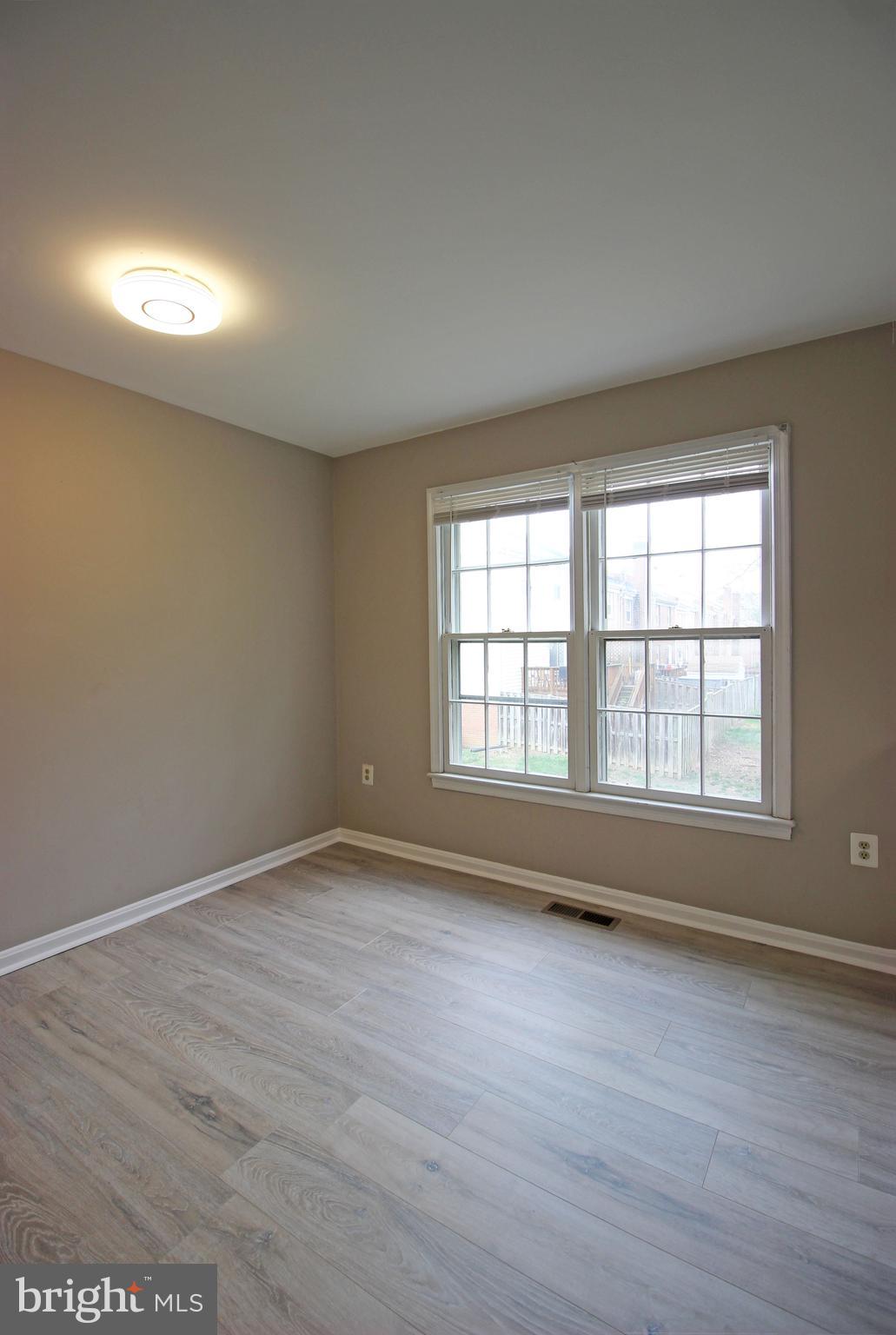 8022 Northumberland Road Springfield, VA 22153 - Photo 11 of 42 an empty room with wooden floor and windows