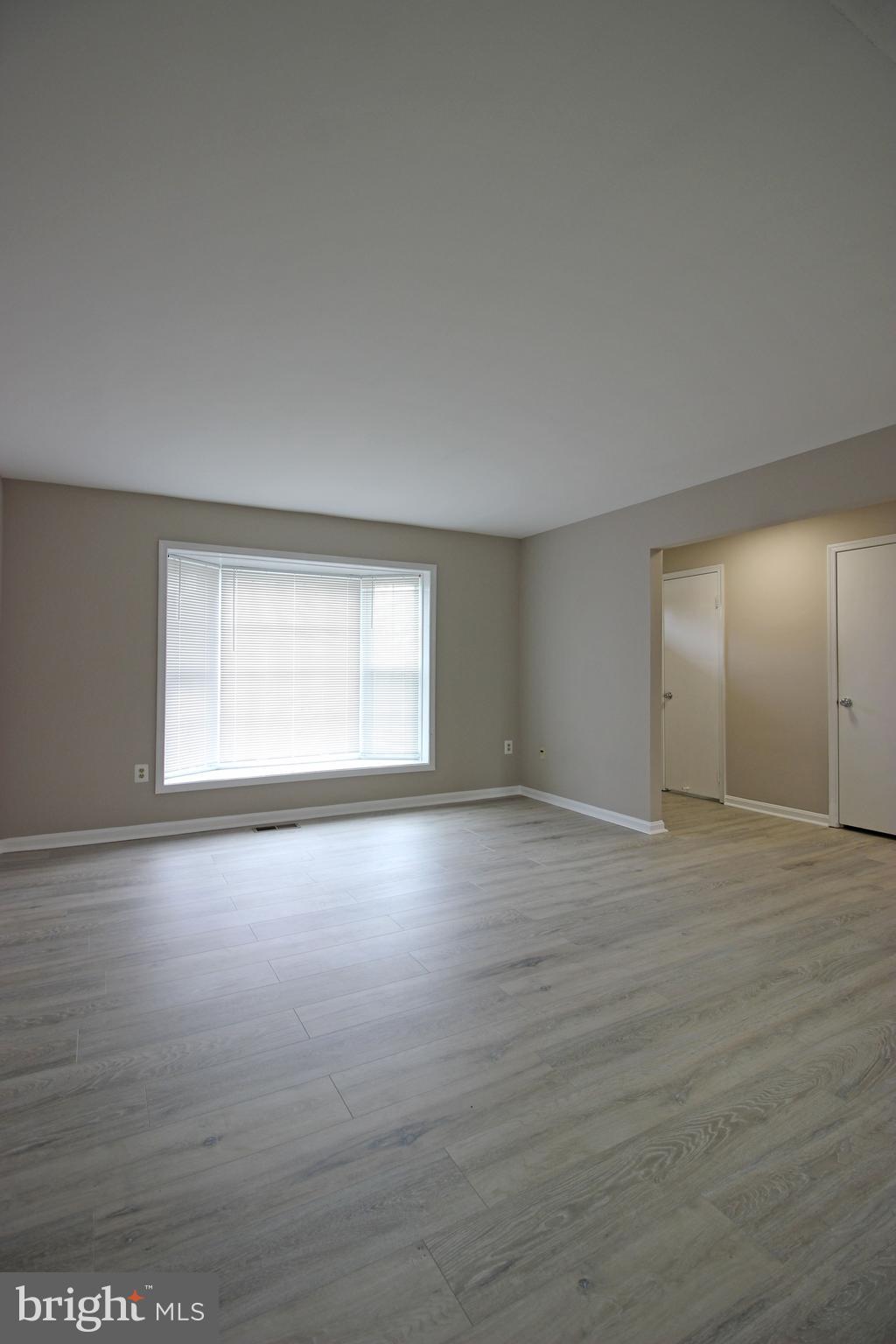8022 Northumberland Road Springfield, VA 22153 - Photo 3 of 42 a view of an empty room with wooden floor and a window