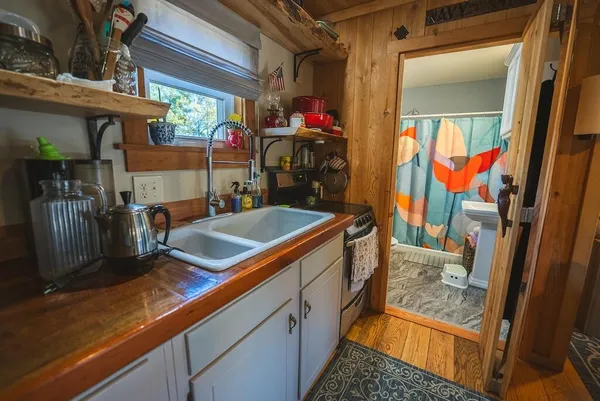 a kitchen with refrigerator and wooden floor