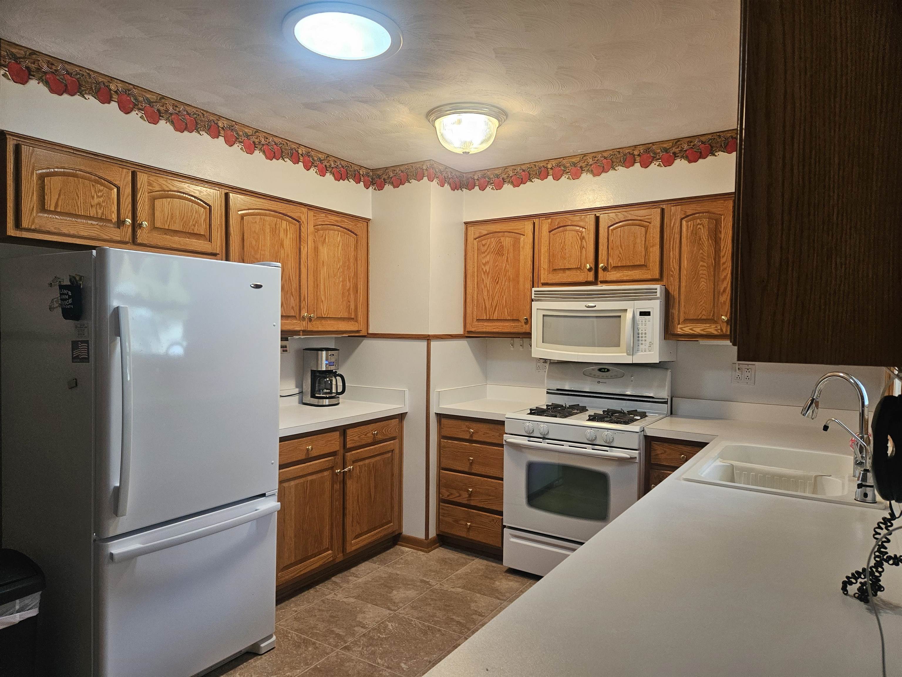 232 East 10th Street Pecatonica, IL 61063 - Photo 11 of 15 a kitchen with a refrigerator a stove top oven a sink and cabinets