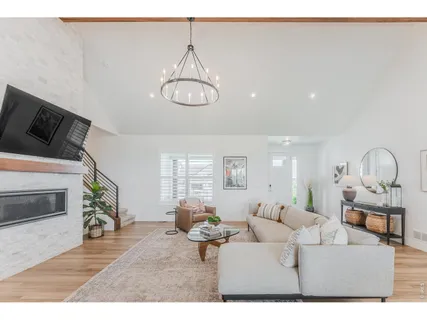 a living room with furniture chandelier and a fireplace