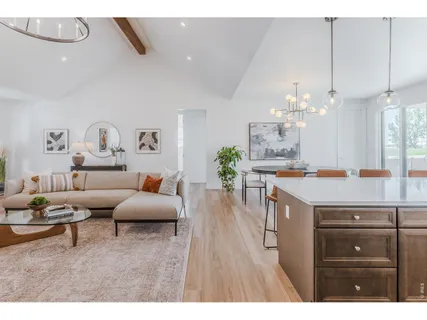 a living room with kitchen island furniture and a chandelier