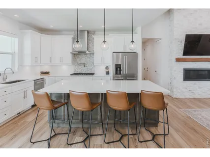 a kitchen with stainless steel appliances kitchen island granite countertop a sink and a white cabinets
