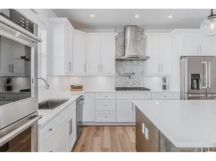 a kitchen with white cabinets sink and white appliances