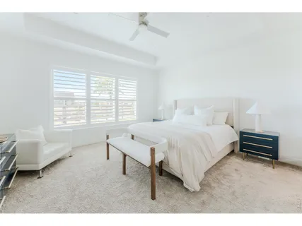 a spacious bedroom with a bed a couch and a window