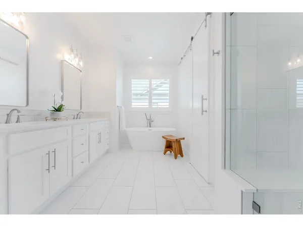 a spacious bathroom with a double vanity sink a mirror and a bathtub