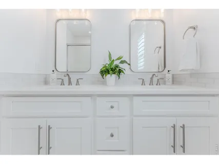 a bathroom with double vanity sinks a vanity and a mirror