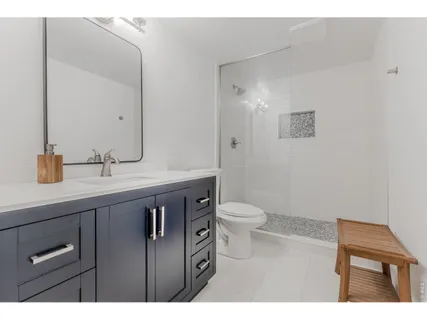 a bathroom with a sink a toilet a mirror and shower